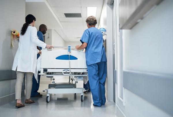 后视镜，一个医疗团队推着一个躺在轮床上的病人走过走廊.